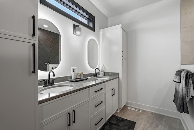 full bath featuring double vanity and baseboards