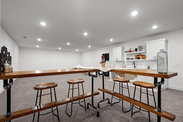 indoor wet bar featuring carpet flooring, recessed lighting, and baseboards