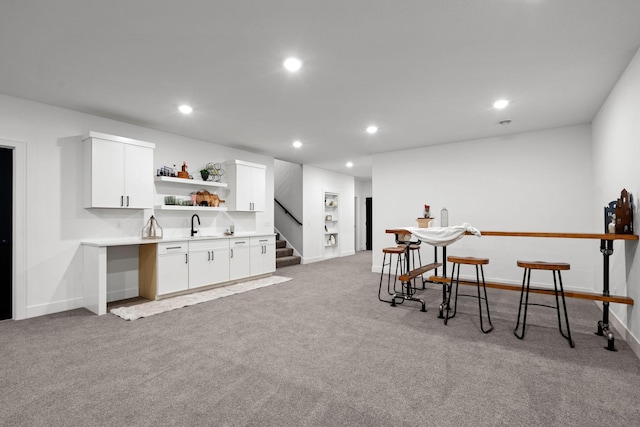 indoor wet bar featuring stairs, recessed lighting, light carpet, and baseboards