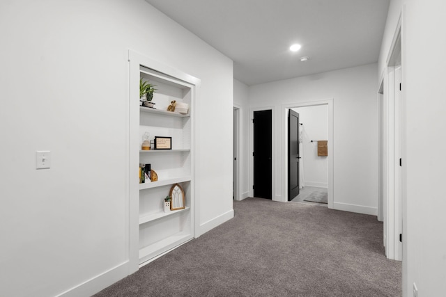 hall with carpet flooring, baseboards, and built in features