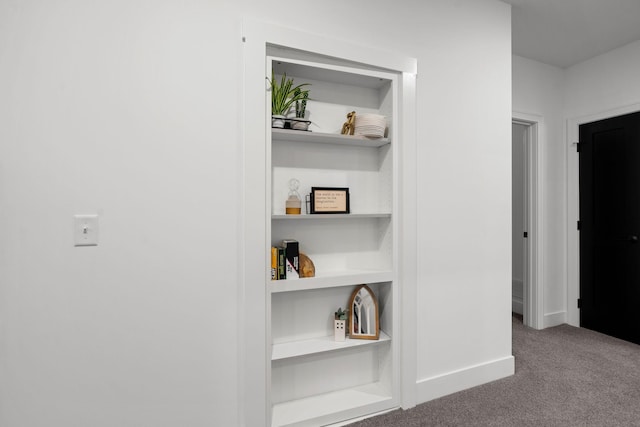 hall featuring carpet flooring and baseboards