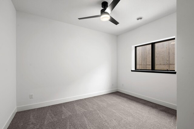 carpeted spare room featuring baseboards and ceiling fan