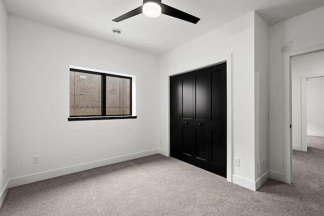 unfurnished bedroom featuring carpet flooring, baseboards, a closet, and ceiling fan