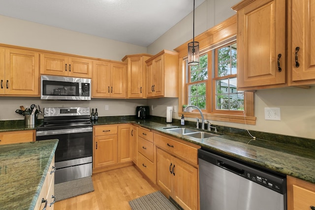 1301 Pondview Ln, Saint Joseph, MN 56374 - kitchen with a sink, light wood-style floors, dark stone countertops, stainless steel appliances, and decorative light fixtures