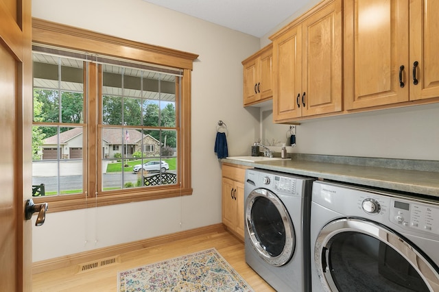 1301 Pondview Ln, Saint Joseph, MN 56374 - laundry room featuring cabinet space, a sink, light wood-style flooring, visible vents, and washing machine and dryer