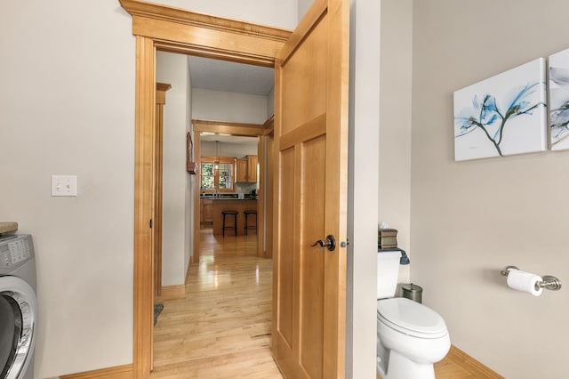 1301 Pondview Ln, Saint Joseph, MN 56374 - bathroom with washer / clothes dryer, toilet, baseboards, and wood finished floors