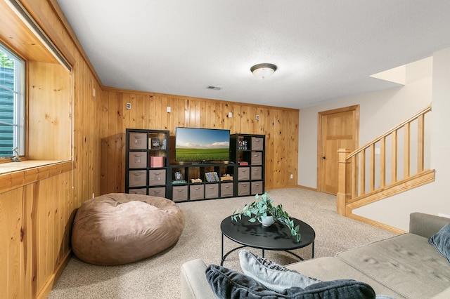 1301 Pondview Ln, Saint Joseph, MN 56374 - carpeted living area featuring wooden walls, baseboards, stairway, and visible vents