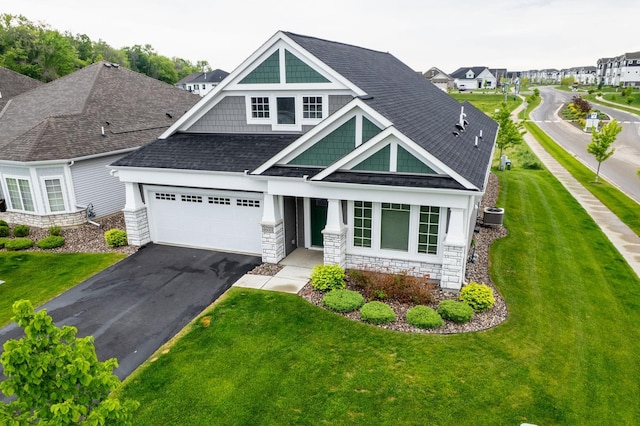 4600 Foxglove Dr, Minnetrista, MN 55331 - view of front of home featuring stone siding, central AC unit, driveway, an attached garage, and roof with shingles