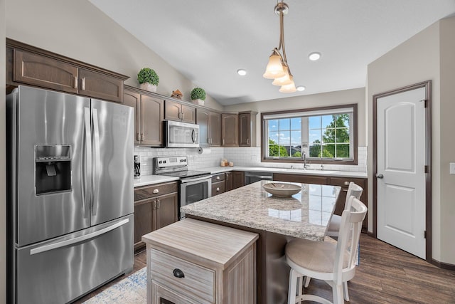 5234 Sundial Ln, Woodbury, MN 55129 - kitchen featuring appliances with stainless steel finishes, lofted ceiling, dark brown cabinetry, tasteful backsplash, and recessed lighting