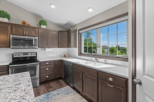 5234 Sundial Ln, Woodbury, MN 55129 - kitchen featuring stainless steel appliances, vaulted ceiling, light countertops, backsplash, and dark wood-style floors