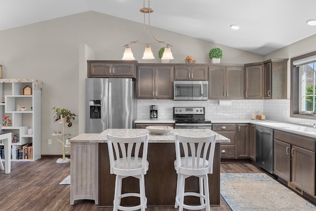 5234 Sundial Ln, Woodbury, MN 55129 - kitchen with appliances with stainless steel finishes, vaulted ceiling, dark brown cabinets, light countertops, and decorative backsplash