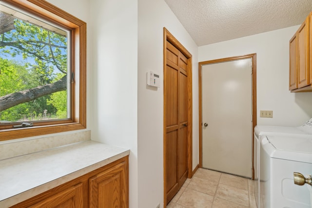 clothes washing area with cabinet space, plenty of natural light, independent washer and dryer, and a textured ceiling