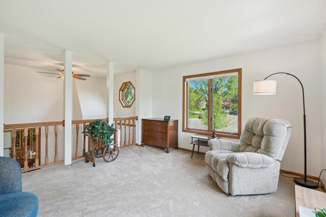 sitting room with a ceiling fan, carpet, and baseboards