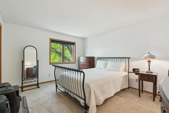 bedroom featuring light carpet and baseboards
