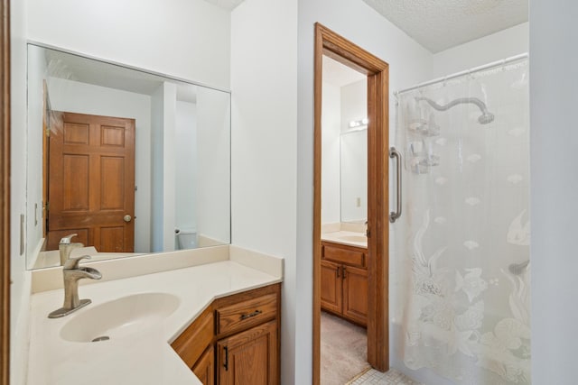 full bath featuring a shower with shower curtain, vanity, and a textured ceiling