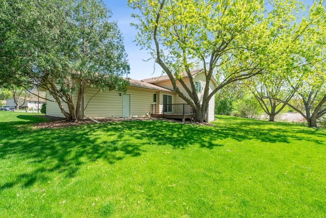 view of green lawn with a deck