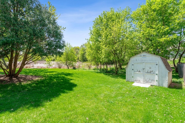 view of green lawn with a shed and an outdoor structure