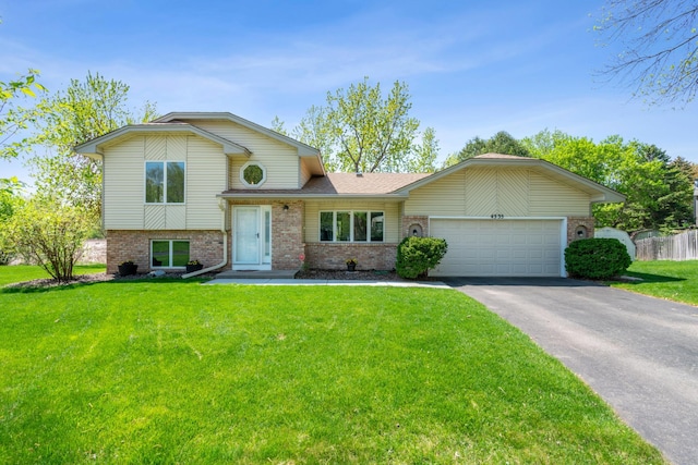 tri-level home with brick siding, driveway, and an attached garage