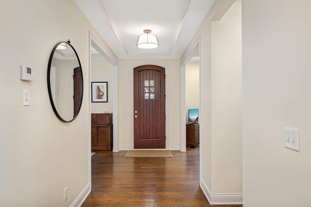 entryway featuring arched walkways, baseboards, and wood finished floors