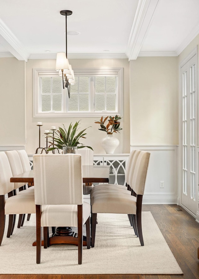 dining space with a wealth of natural light, crown molding, and wood finished floors