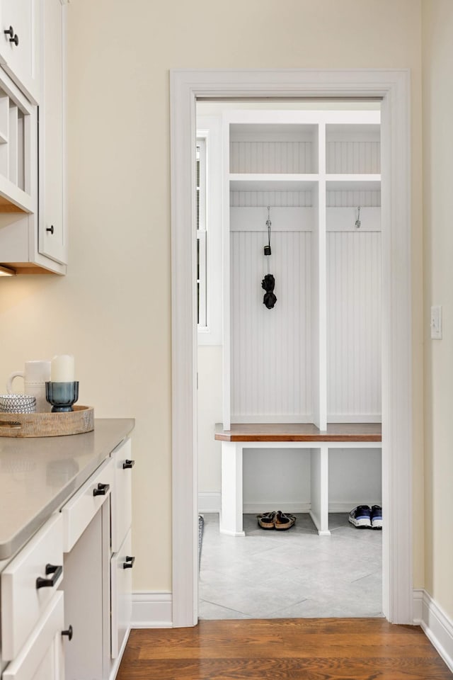 mudroom featuring dark wood-type flooring and baseboards