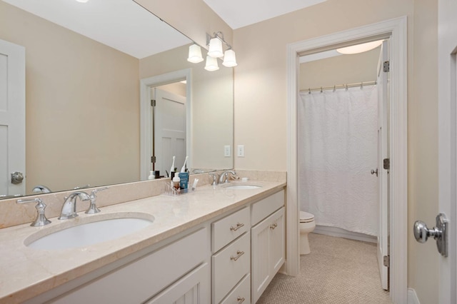 bathroom with toilet, a sink, double vanity, and tile patterned floors