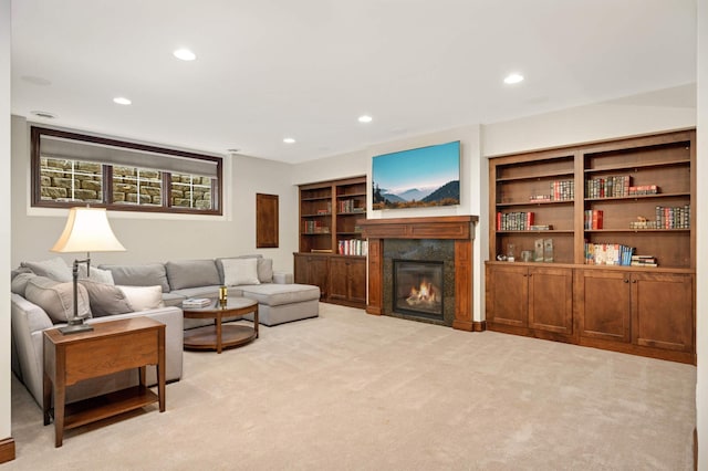 living room featuring a high end fireplace, recessed lighting, and light colored carpet