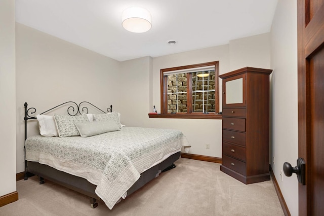 bedroom featuring baseboards, light colored carpet, and visible vents