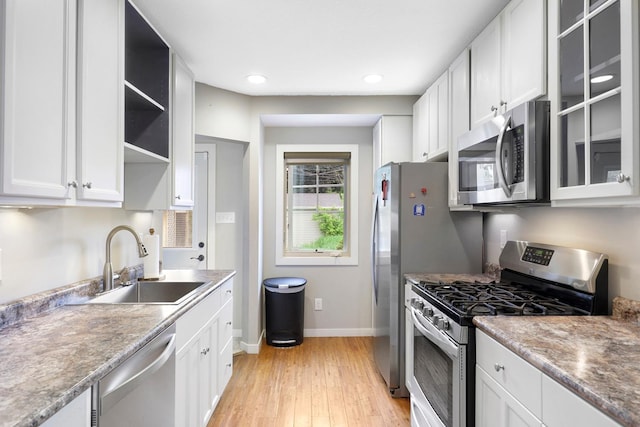 5441 44th Ave S, Minneapolis, MN 55417 - kitchen with stainless steel appliances, a sink, baseboards, light wood-type flooring, and white cabinetry