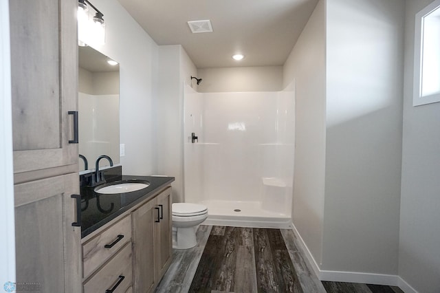 8072 Goldfinch Dr, Horace, ND 58047 - bathroom featuring wood finished floors, vanity, toilet, a shower, and baseboards