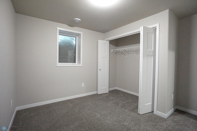 8072 Goldfinch Dr, Horace, ND 58047 - unfurnished bedroom with dark carpet, baseboards, and a closet