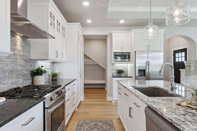 3725 Queensland Ln N, Plymouth, MN 55446 - kitchen with wall chimney exhaust hood, appliances with stainless steel finishes, white cabinetry, a sink, and light wood-style floors