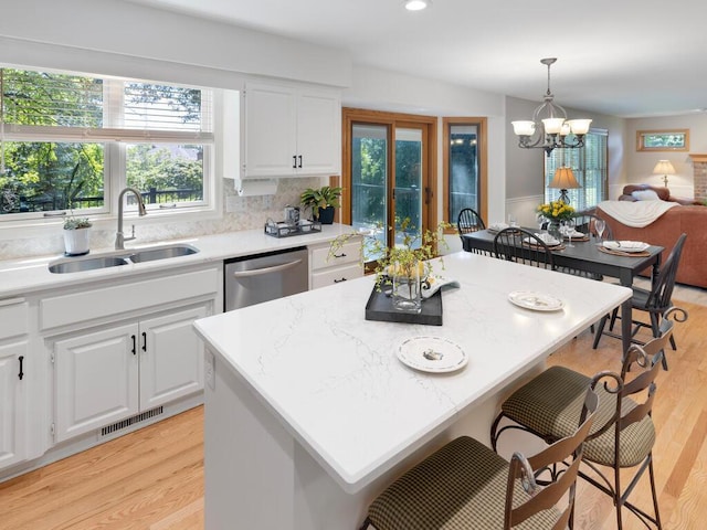 8118 Currant Pl, Eden Prairie, MN 55347 - kitchen with a breakfast bar area, dishwasher, white cabinetry, light wood-style floors, and recessed lighting