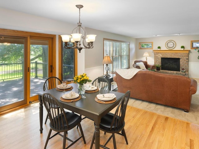 8118 Currant Pl, Eden Prairie, MN 55347 - dining area with healthy amount of natural light, a chandelier, a wainscoted wall, and light wood-type flooring
