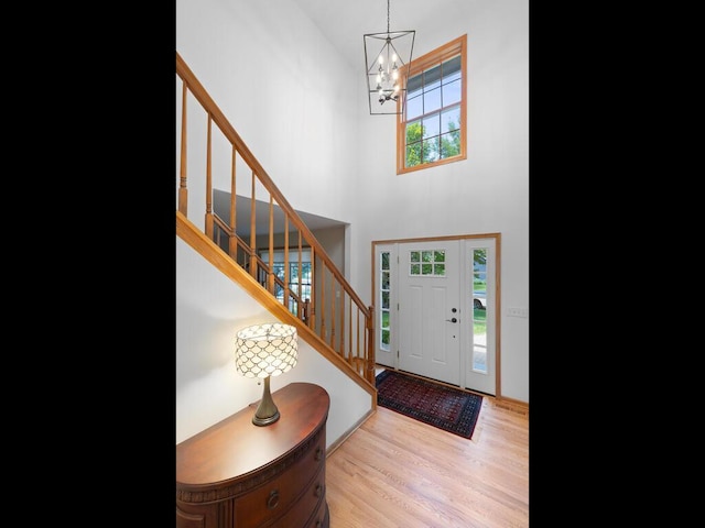 8118 Currant Pl, Eden Prairie, MN 55347 - foyer entrance with a chandelier, a high ceiling, stairs, and light wood-style floors