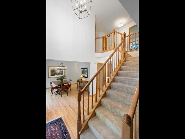 8118 Currant Pl, Eden Prairie, MN 55347 - staircase featuring a chandelier, wood finished floors, and a towering ceiling