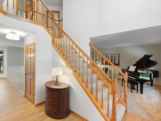 8118 Currant Pl, Eden Prairie, MN 55347 - staircase featuring wood finished floors, a high ceiling, and a wainscoted wall