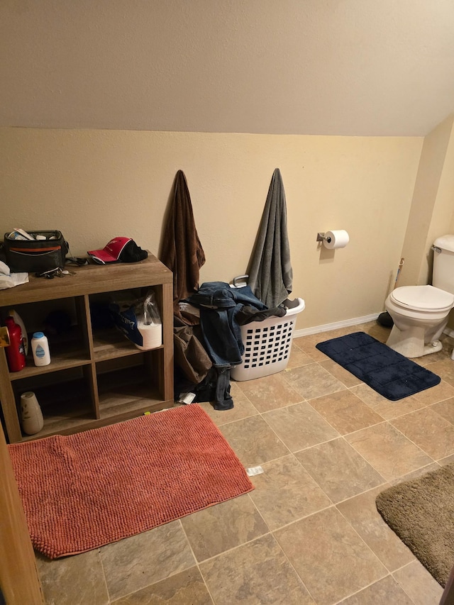 interior space with toilet and baseboards
