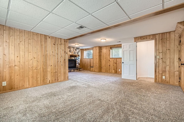 4 Battle Creek Ct, Saint Paul, MN 55119 - unfurnished living room with carpet floors, wooden walls, a stone fireplace, and a drop ceiling