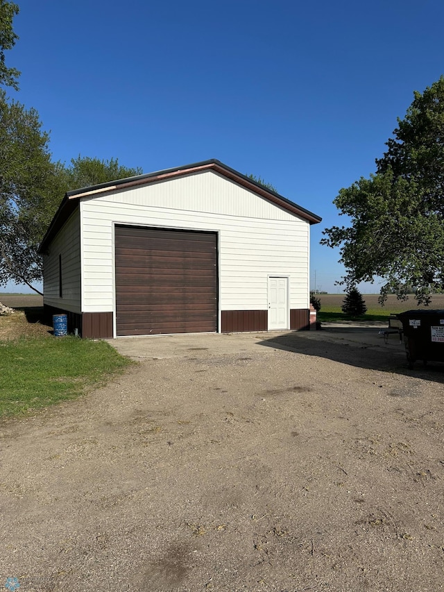 detached garage featuring dirt driveway