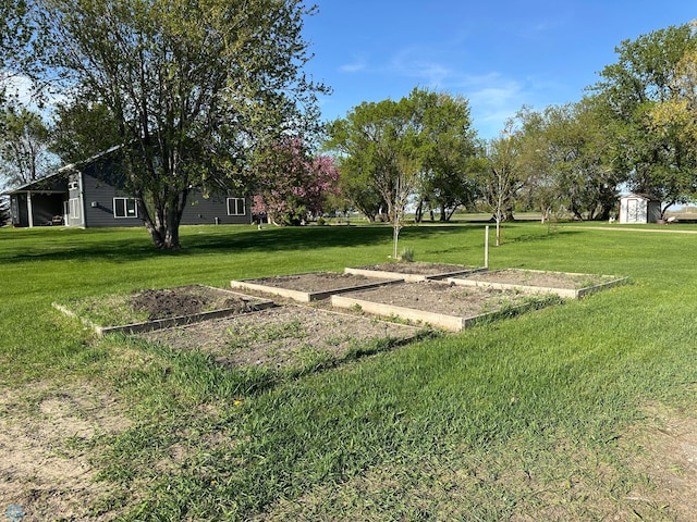 view of grassy yard featuring a storage shed and an outbuilding