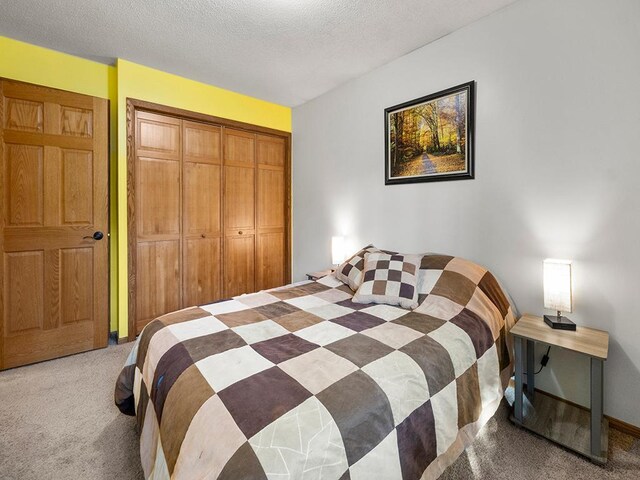 15029 Tyacke Dr, Burnsville, MN 55306 - bedroom featuring light carpet, baseboards, a closet, and a textured ceiling