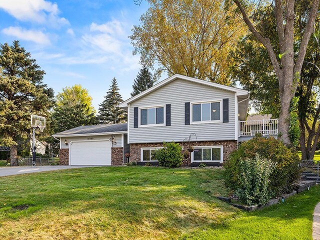 15029 Tyacke Dr, Burnsville, MN 55306 - split level home featuring a front yard, a garage, brick siding, and aphalt driveway