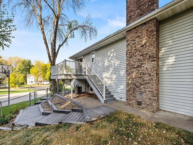 15029 Tyacke Dr, Burnsville, MN 55306 - exterior space featuring fence, central AC unit, a chimney, stairway, and a deck