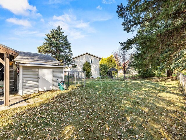 15029 Tyacke Dr, Burnsville, MN 55306 - view of yard featuring a fenced backyard, a storage unit, and an outdoor structure