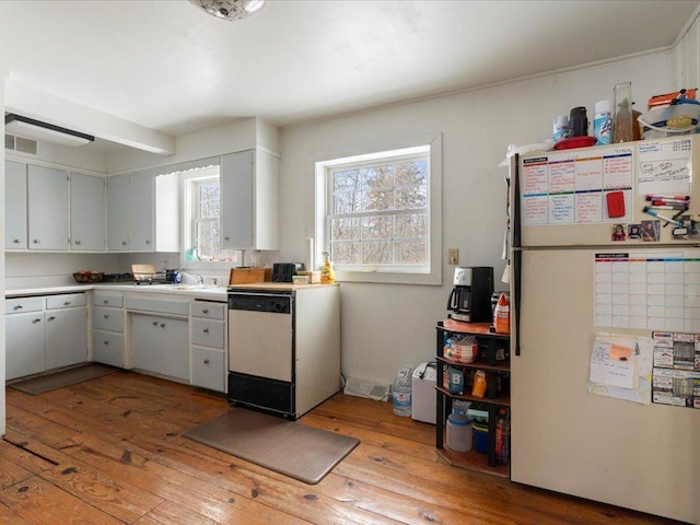 17430 280th St, Sebeka, MN 56477 - kitchen featuring freestanding refrigerator, dishwashing machine, light wood finished floors, and light countertops