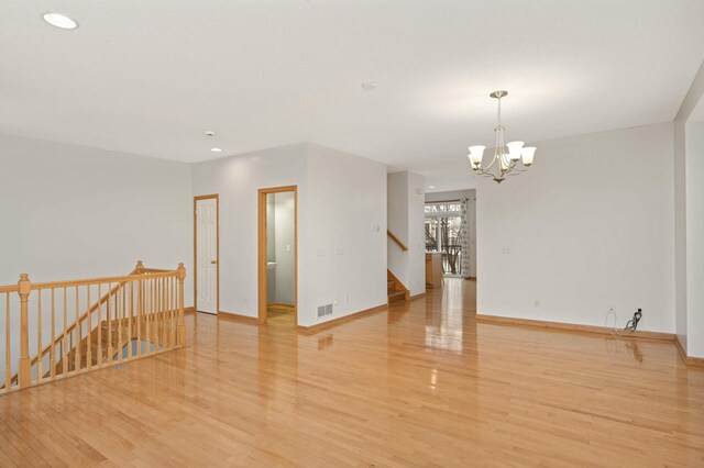 15767 Porchlight Ln, Eden Prairie, MN 55347 - unfurnished room with stairs, an inviting chandelier, baseboards, visible vents, and light wood-style flooring