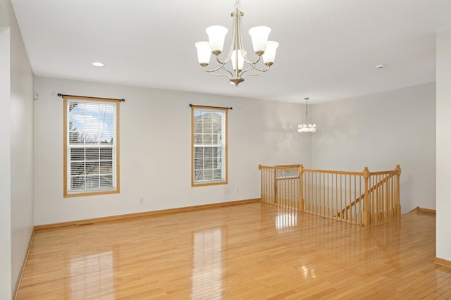15767 Porchlight Ln, Eden Prairie, MN 55347 - unfurnished room featuring light wood finished floors, baseboards, and a notable chandelier