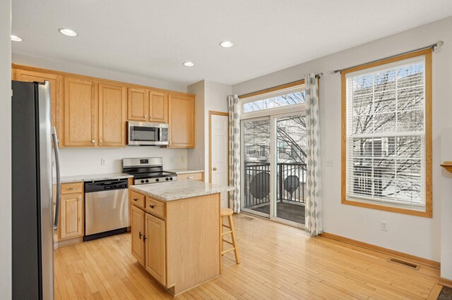 15767 Porchlight Ln, Eden Prairie, MN 55347 - kitchen featuring light brown cabinets, appliances with stainless steel finishes, a center island, and visible vents