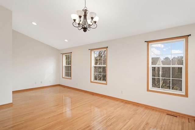 15767 Porchlight Ln, Eden Prairie, MN 55347 - empty room featuring a healthy amount of sunlight, visible vents, light wood-style flooring, and a chandelier